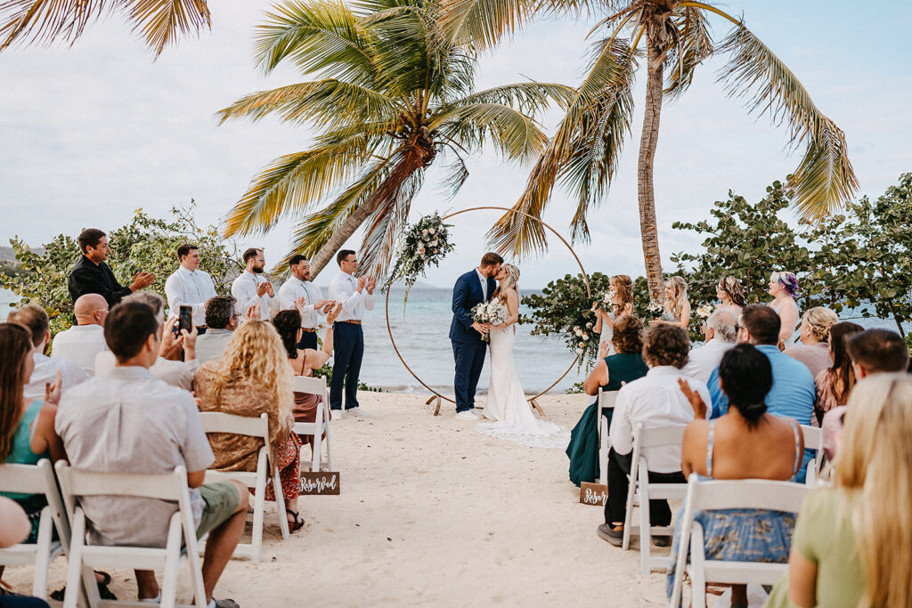 bride and groom share first kiss at beach ceremony during usvi destination wedding