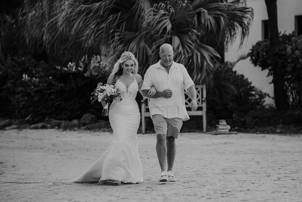 bride walking down beach with dad during her usvi destination wedding 