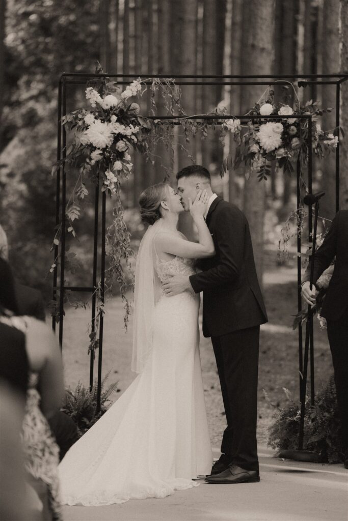 first kiss at outdoor ceremony at pinewood