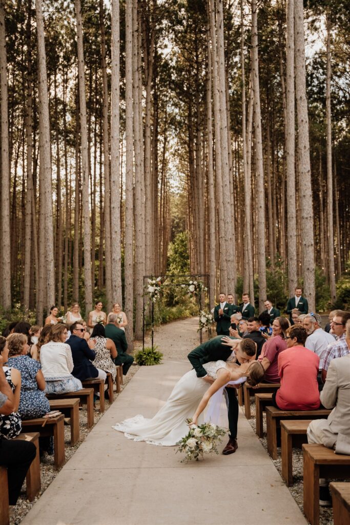 first kiss at outdoor ceremony at pinewood